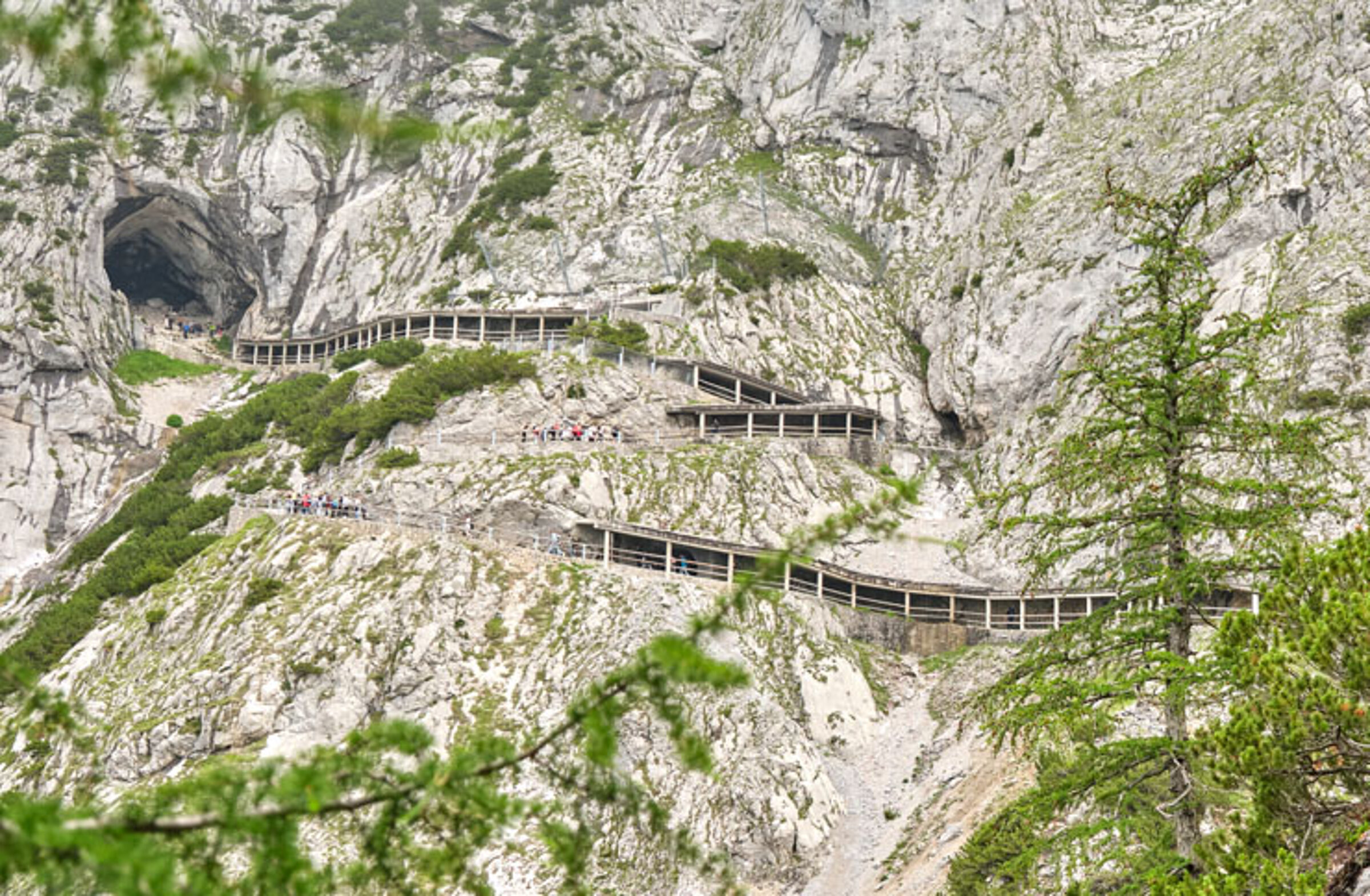 A winding path with railings winds its way up a rocky mountainside to the cave entrance of the ice giant world.
