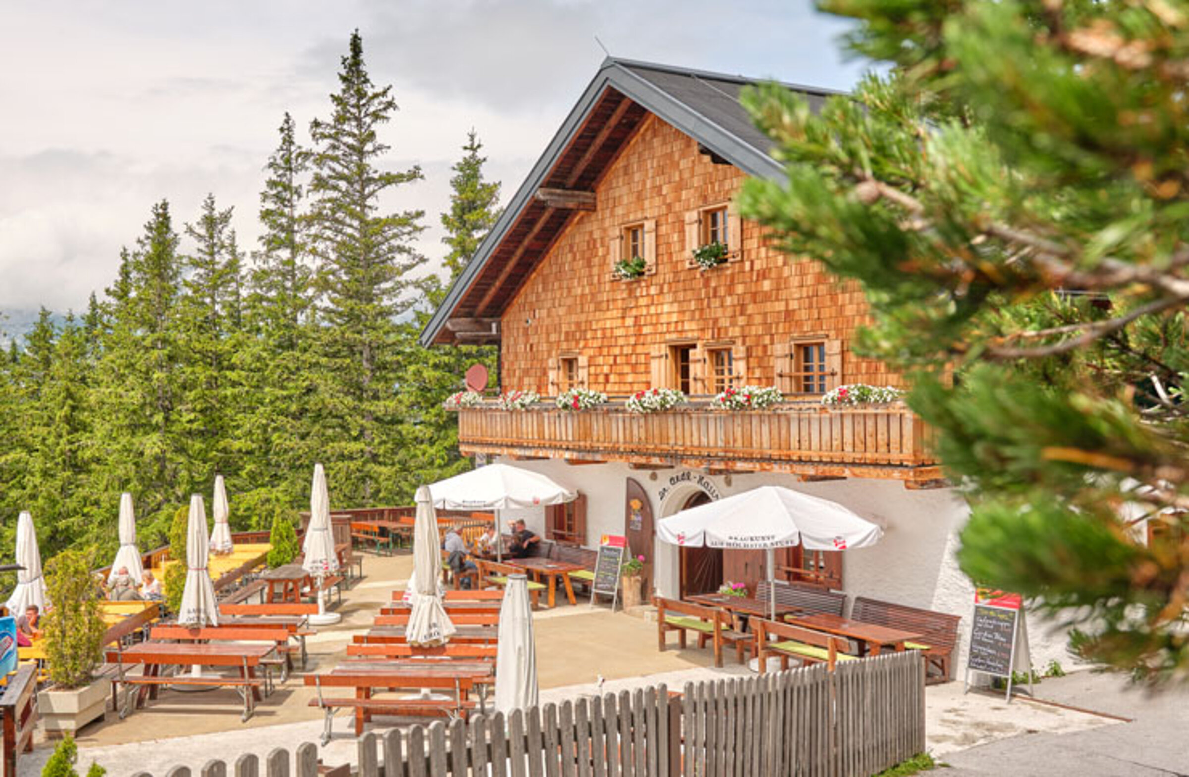Das Dr.-Friedrich-Oedl-Schutzhaus ist ein rustikales Alpengasthaus mit einem Holzbalkon mit Blumenkästen und ist von Kiefern umgeben. Genießen Sie die Sitzgelegenheiten auf der Terrasse und die Aussicht auf die berühmte Eisriesenwelt.